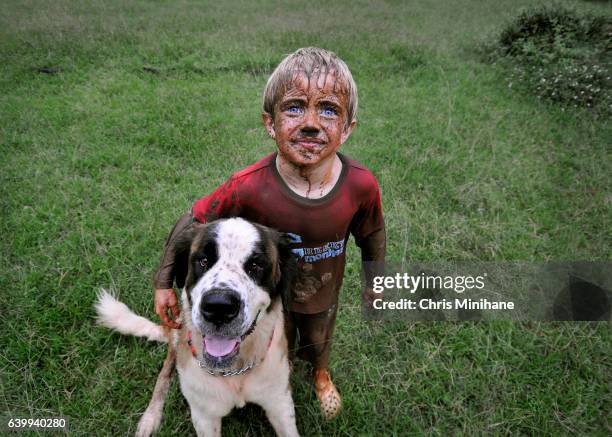 muddy, messy child with dog - messy dog stockfoto's en -beelden