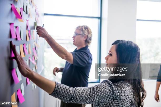 brainstorming with notes on the wall - postit stockfoto's en -beelden