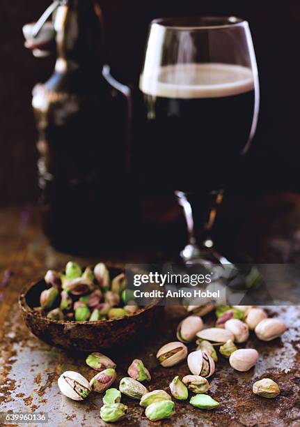 pistachios and black beer - beer nuts stock-fotos und bilder