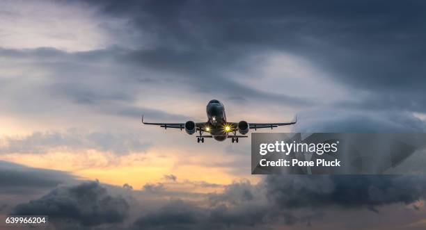 airplane landing in dramatic sunset - business air travel photos et images de collection