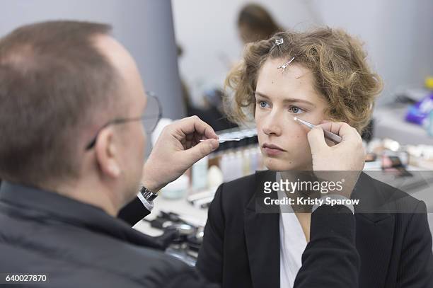 Belgian Makeup Artist, Peter Philips completes Maria Zakrzewska's makeup backstage prior the Christian Dior Spring Summer 2017 show as part of Paris...