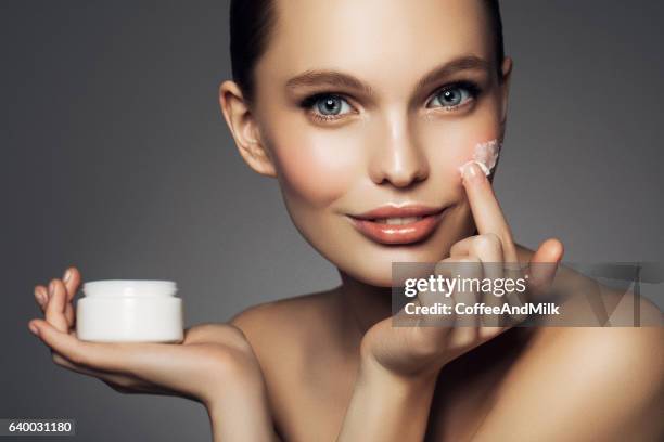 girl inflicting cream - stage make up stock pictures, royalty-free photos & images