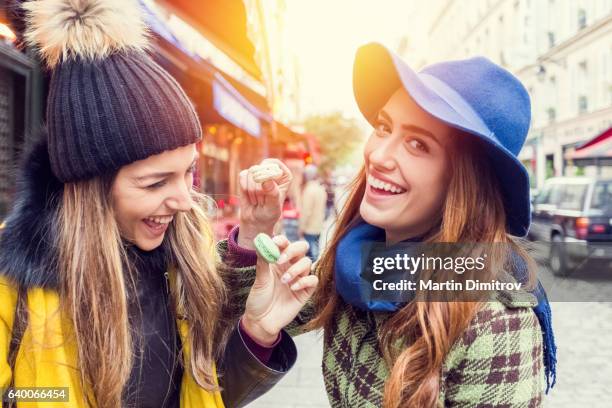 friends eating parisian macaroons - sassy paris stock pictures, royalty-free photos & images