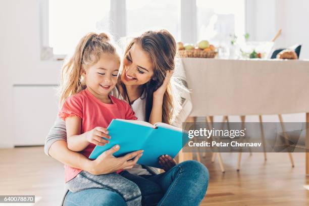 mutter und tochter lesen buch - girl sitting on floor stock-fotos und bilder