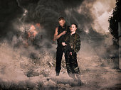 girl and man in military camouflage uniforms among the ruins