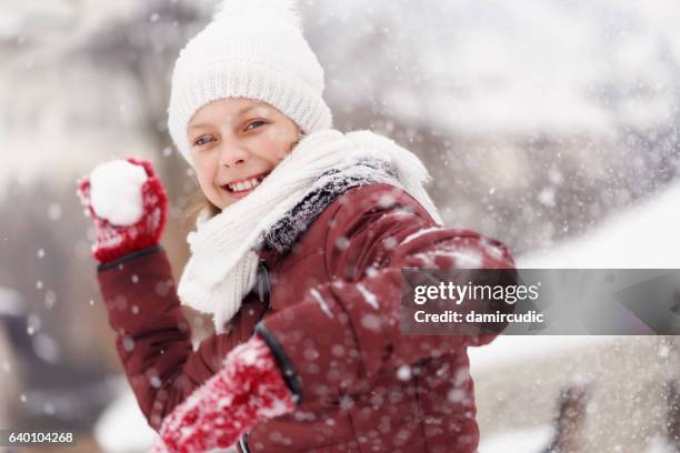 smiling teenage girl throwing snowball - winter acitivities - snowball stock pictures, royalty-free photos & images