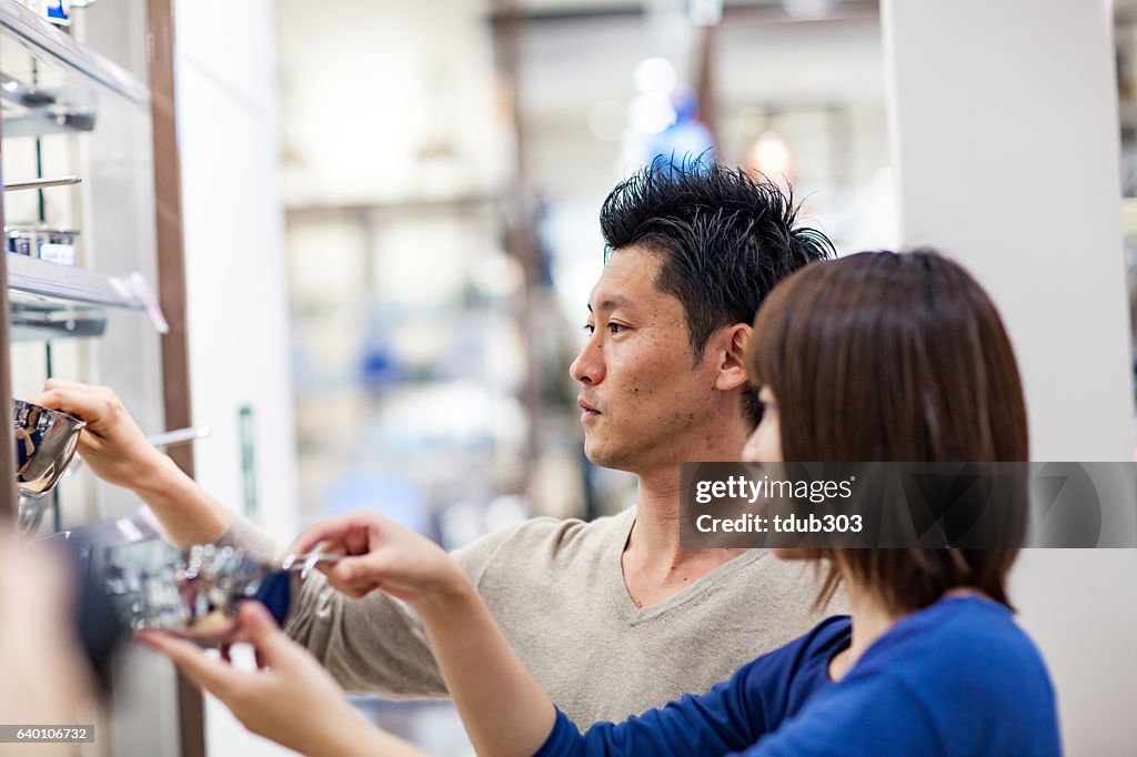 Newlywed couple selecting cookware at a department store