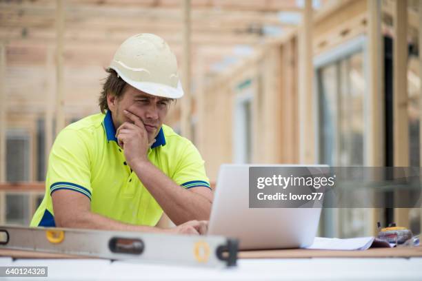 foreman checking plans on a laptop - computer framework stock pictures, royalty-free photos & images