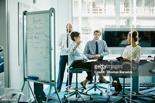 mature businesswoman leading meeting in office - responsibility stock-fotos und bilder