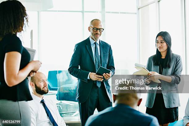 businessman in discussion with colleagues - happy asian woman bright office stock-fotos und bilder
