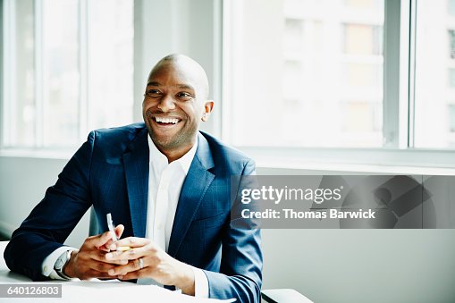 Smiling businessman in discussion at workstation Smiling businessman in discussion at workstation