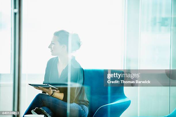 businesswoman holding digital tablet in meeting - glass reflection in office stock pictures, royalty-free photos & images