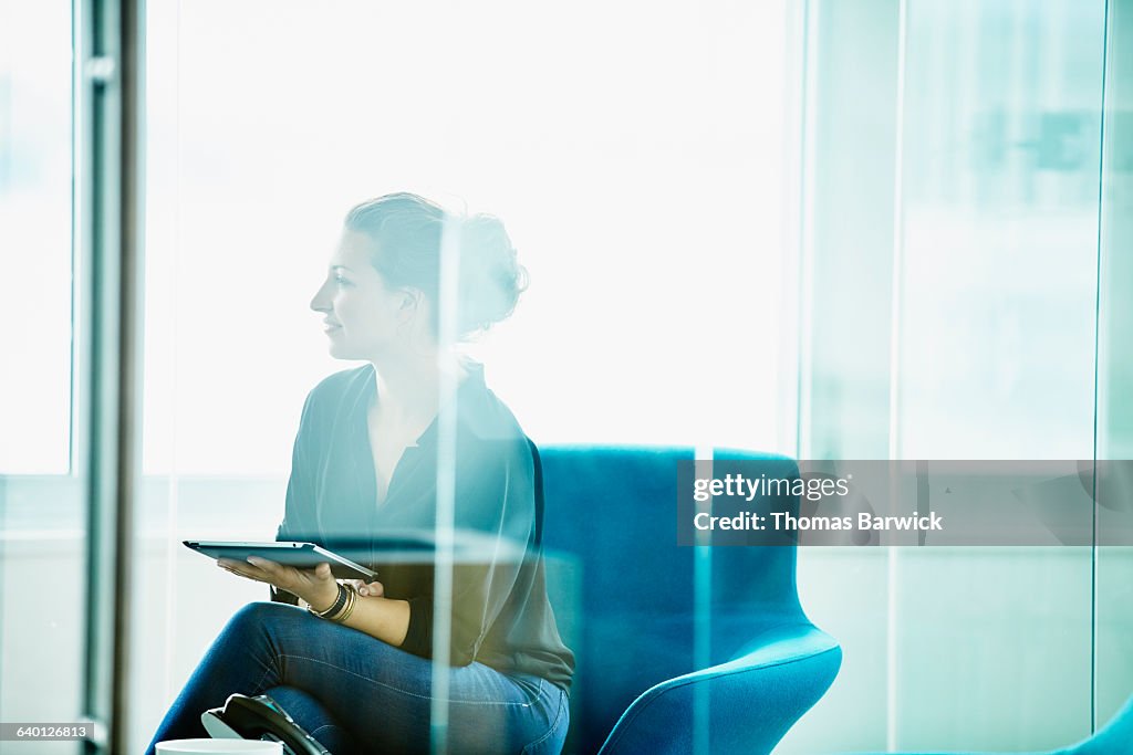Businesswoman holding digital tablet in meeting