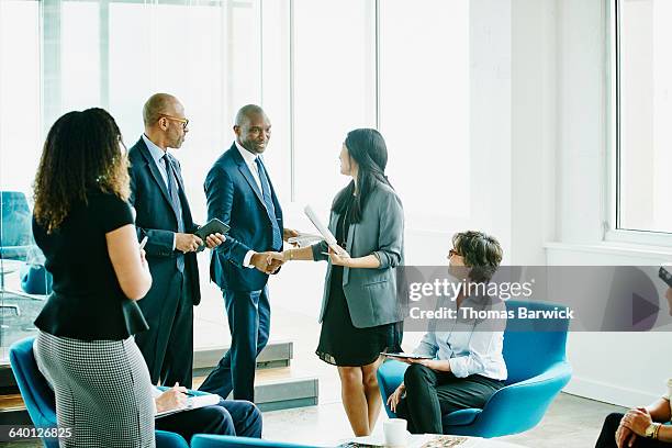 businessman shaking hands with colleague - corporate modern office bright diverse stock pictures, royalty-free photos & images