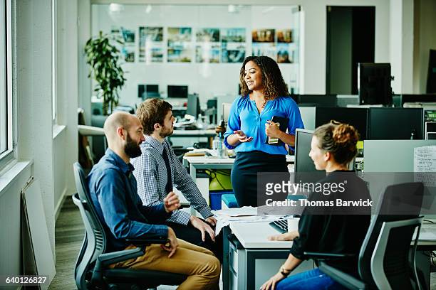 businesswoman leading meeting with colleagues - management stockfoto's en -beelden