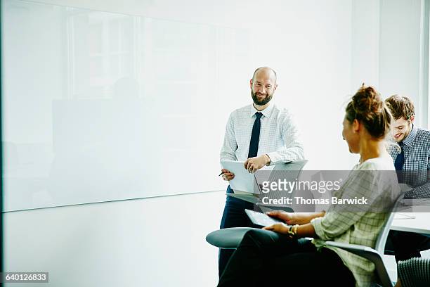 laughing businesspeople in meeting in office - bright white people stock pictures, royalty-free photos & images