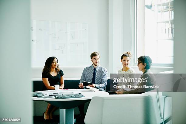mature businesswoman leading project meeting - four people business talking stock pictures, royalty-free photos & images