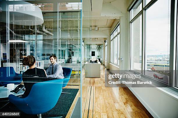 businessman and businesswoman discussing project - inside the bicycle corporation of america assembly facility stockfoto's en -beelden