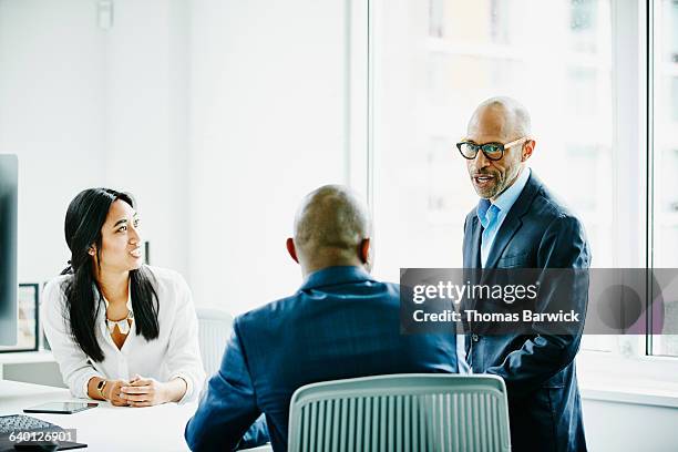 mature businessman leading meeting with colleagues - business woman blue stock-fotos und bilder