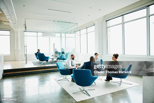 businesswoman shaking hands with client - mann sitzt auf stuhl stock-fotos und bilder