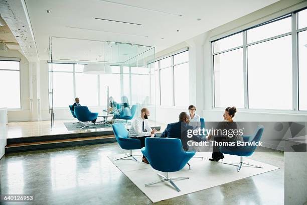 businesswoman shaking hands with client - blue armchair stock pictures, royalty-free photos & images