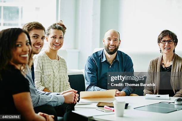 smiling group of businesspeople in team meeting - corporate modern office bright diverse stock pictures, royalty-free photos & images