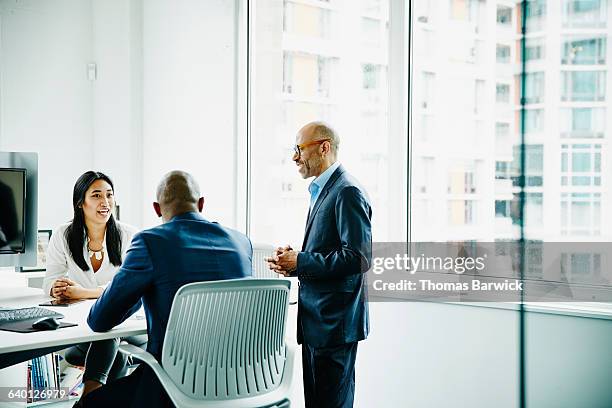 business colleagues discussing project in office - three people standing stock pictures, royalty-free photos & images