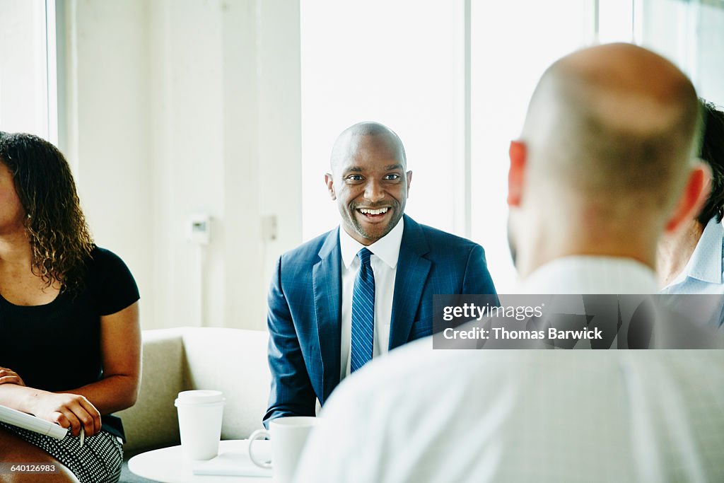 Smiling businessman in discussion with colleagues