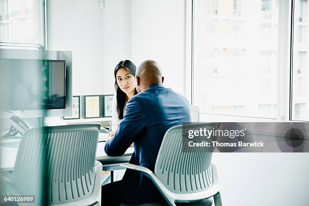 two colleagues in meeting in office - doing a favor - fotografias e filmes do acervo