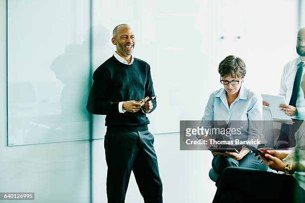 laughing mature businessman in meeting - three quarter length stock pictures, royalty-free photos & images