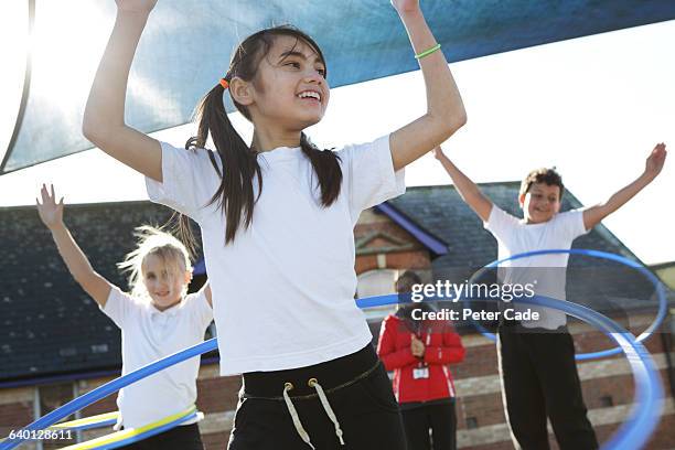 children doing pe in school with hoops - sportunterricht stock-fotos und bilder