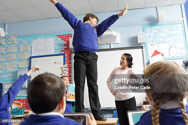 boy in trouble for standing on table in class - naughty in class stock pictures, royalty-free photos & images