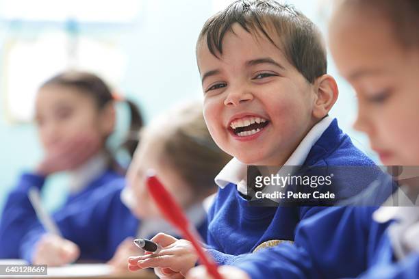 happy boy in class at school - primary school children in uniform stock pictures, royalty-free photos & images
