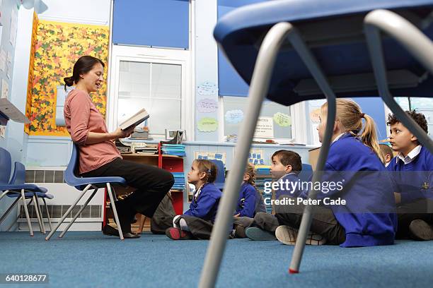 teacher reading to children in class - school teacher blue stock-fotos und bilder