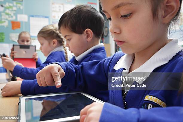 children in school working on tablets - children working at school stock pictures, royalty-free photos & images
