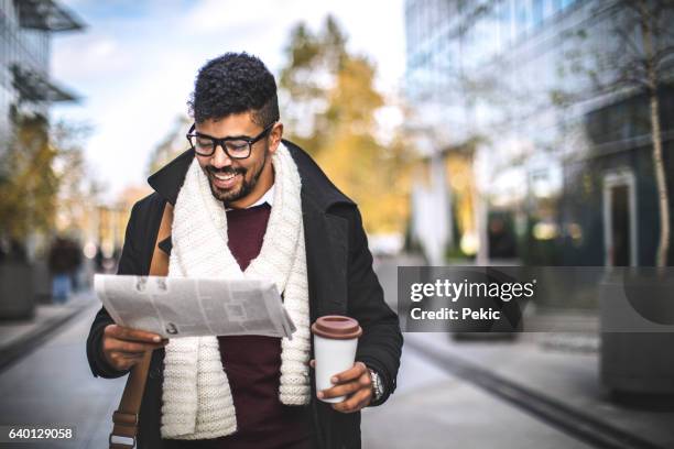 joven empresario leyendo noticias de última hora - periodismo fotografías e imágenes de stock