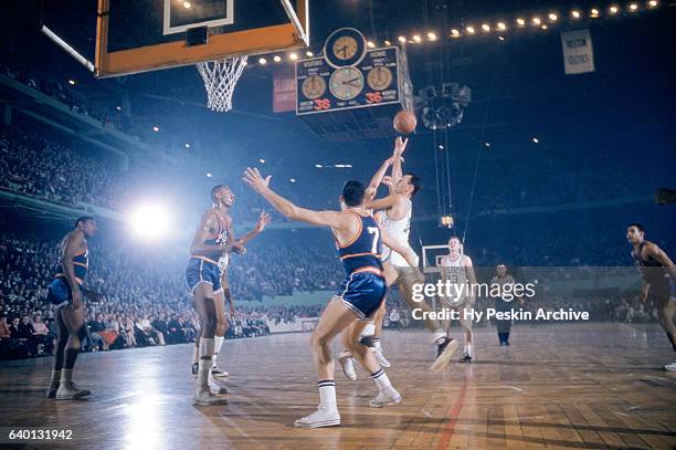 Bob Cousy of the Boston Celtics shoots over Ernie Beck and Wilt Chamberlain of the Philadelphia Warriors during an NBA game circa 1959 at the Boston...