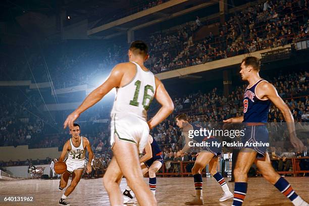 Bob Cousy of the Boston Celtics dribbles the ball as his teammate Jack Nichols looks for a pass during an NBA game against the Ft. Wayne Pistons...