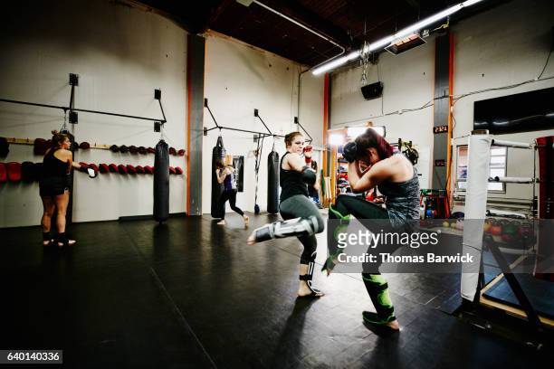 female fighters training together in fighting gym - mixed martial arts stock pictures, royalty-free photos & images