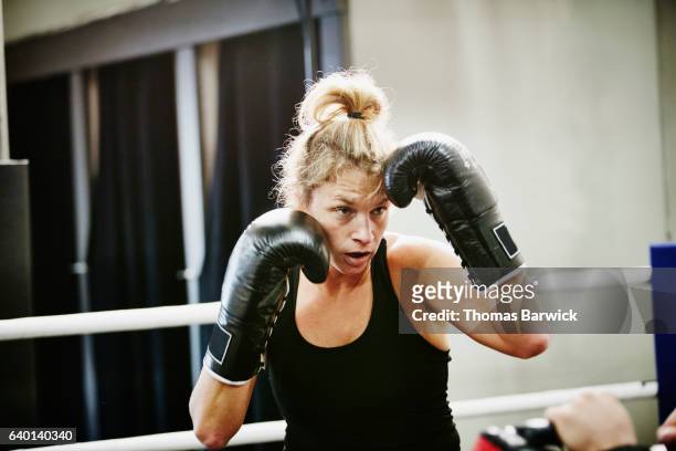 Female kickboxer working out in ring in gym