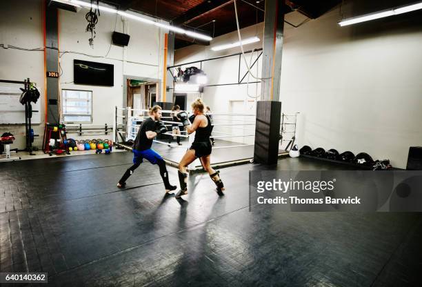 female kickboxer working out with trainer in gym - mixed martial arts stock pictures, royalty-free photos & images