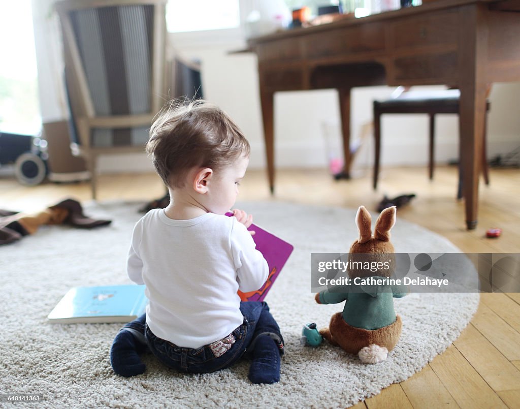 A boy reading a book to his rabbit