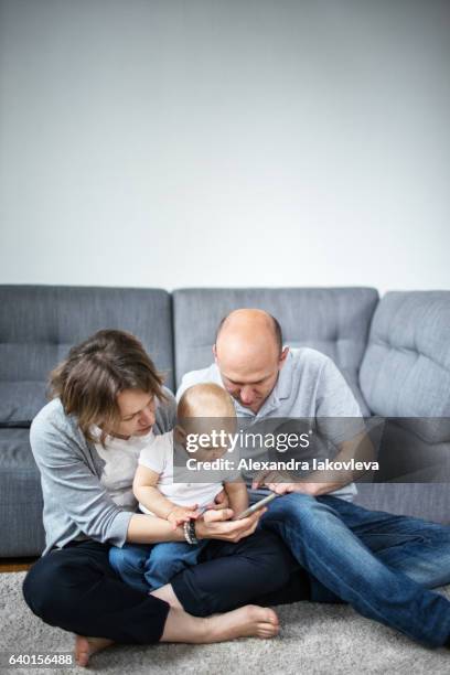 family with a child using a smartphone - alexandra iakovleva stock pictures, royalty-free photos & images