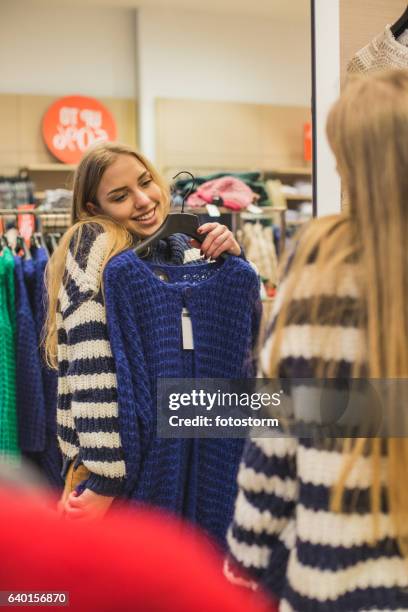 mädchen bewundern strickjacke im spiegel - girl changing room shop stock-fotos und bilder