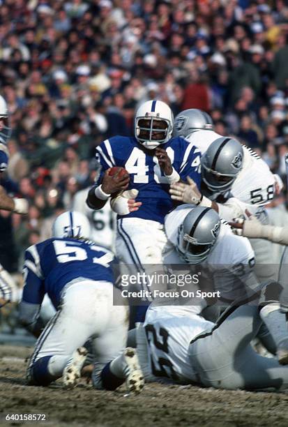 Roosevelt Leaks of the Baltimore Colts gets tackled by Monte Johnson, Willie Hall and Floyd Rice of the Oakland Raiders during The AFC Divisional...