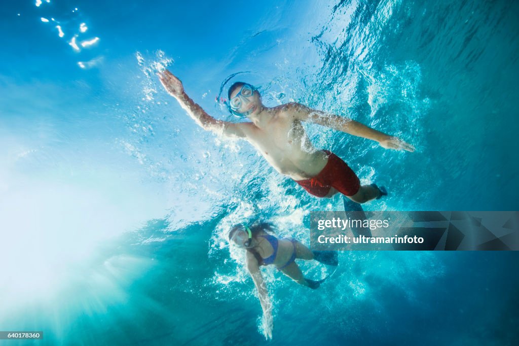 Young man and woman snorkeling  Underwater diving adventure  Turquoise sea