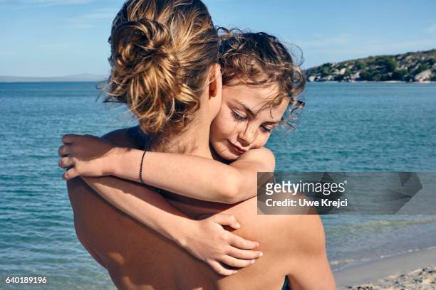 girl hugging her mother on beach - semi dress stock pictures, royalty-free photos & images