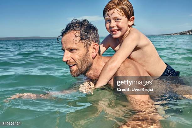 mother and daughter playing in the sea - mother and child in water at beach stock pictures, royalty-free photos & images