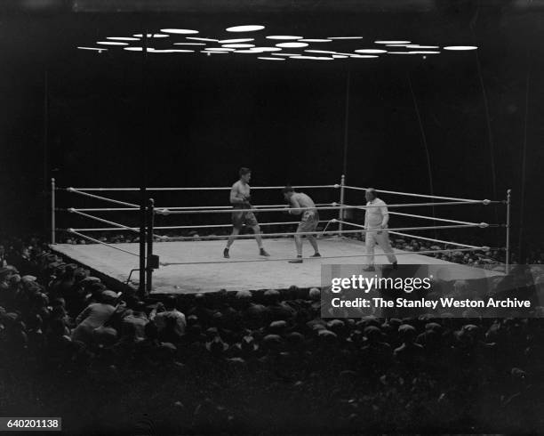 Gene Tunney squares up with Jack Dempsey as referee Tommy Reilly watches, at Sesquicentennial Stadium, Philadelphia, Pennsylvania, September 23,...