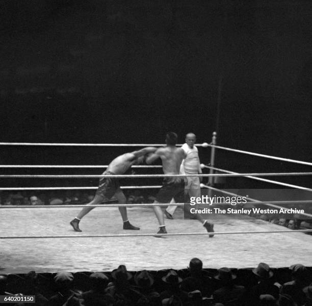 Gene Tunney and Jack Dempsey exchange blows as referee Tommy Reilly watches, at Sesquicentennial Stadium, Philadelphia, Pennsylvania, September 23,...